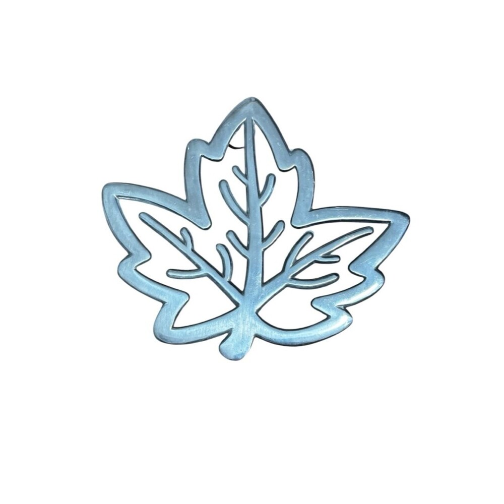 Copco cast aluminum heat resistant trivet featuring a maple leaf design.